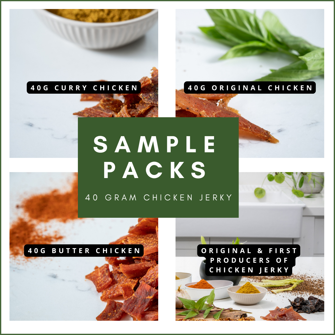 Sample packs of handcrafted chicken jerky, including curry, original, and butter flavors, displayed with herbs and spices.